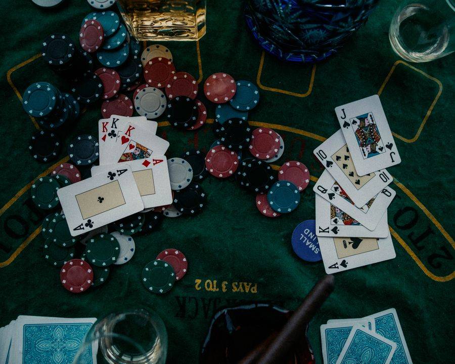 Kartu remi dan chip poker di atas meja hijau