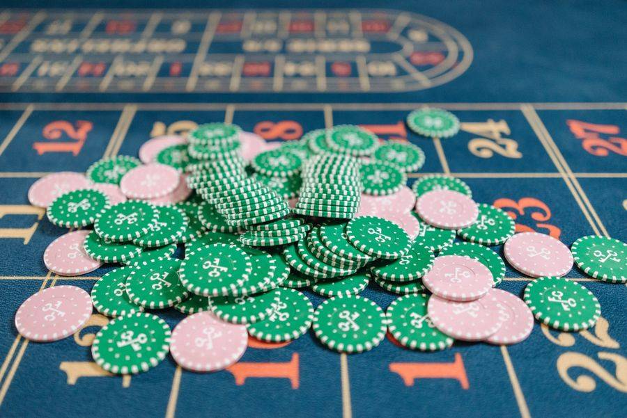 Tumpukan chip poker warna-warni di atas meja